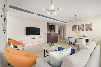 a living room with a couch and a dining room at Silkhaus Expansive 2BDR in DIFC Sky Gardens in Dubai