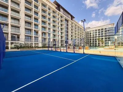 a tennis court in front of a building at GuestReady - Spacious 1 bedroom apartment in Dubai