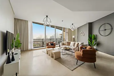 a living room with couches and chairs and a large window at Silkhaus Expansive 2BDR in Sky Gardens DIFC in Dubai