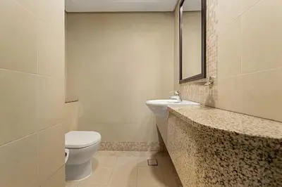 a bathroom with a sink and a toilet and a mirror at Silkhaus Expansive 2BDR in Sky Gardens DIFC in Dubai