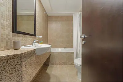 a bathroom with a sink and a toilet and a mirror at Silkhaus Expansive 2BDR in Sky Gardens DIFC in Dubai