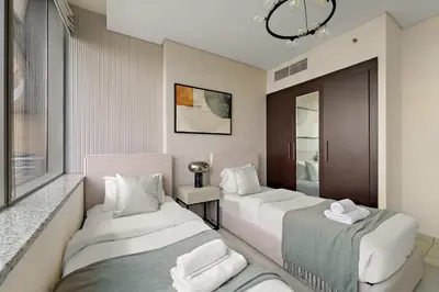 a hotel room with two beds and a mirror at Silkhaus Expansive 2BDR in Sky Gardens DIFC in Dubai
