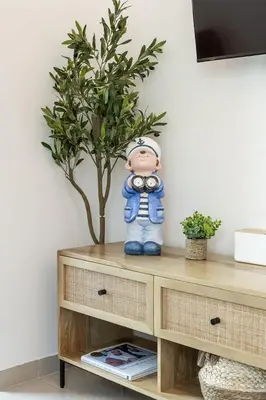a doll sitting on top of a wooden cabinet with a plant at Airstay - Full Marina Views - Coastal Studio - Monthly Offer Available! in Dubai