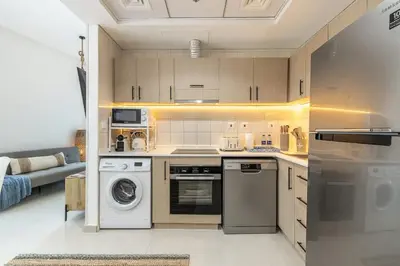 a kitchen with a stove and a washer and dryer at Airstay - Full Marina Views - Coastal Studio - Monthly Offer Available! in Dubai
