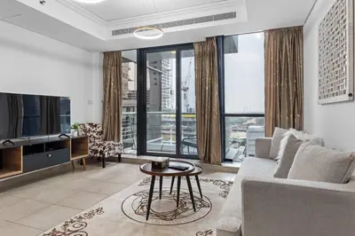a living room with a couch and a table at Modern 2BR Apartment - City Views - Goldcrest Views 2 in Dubai