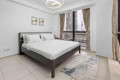 a bedroom with a bed and a large window at Modern 2BR Apartment - City Views - Goldcrest Views 2 in Dubai
