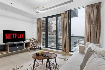 a living room with a couch and a tv at Modern 2BR Apartment - City Views - Goldcrest Views 2 in Dubai