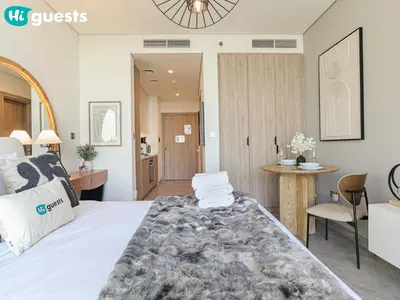 a bedroom with a bed and a table with a chair at HiGuests - Dubai Skyline Studio with Premier Views in Dubai