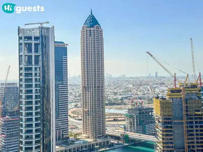 a group of tall buildings in a city with cranes at HiGuests - Dubai Skyline Studio with Premier Views in Dubai