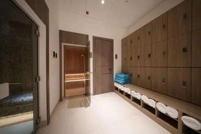 a locker room with wooden cabinets and towels at Elegant 1BR with Balcony in West Five Business Bay in Dubai