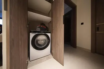 a laundry room with a washing machine in a room at Elegant 1BR with Balcony in West Five Business Bay in Dubai