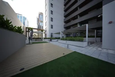 a courtyard of a building with a wooden deck and grass at Elegant 1BR with Balcony in West Five Business Bay in Dubai