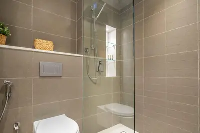 a bathroom with a toilet and a glass shower at Frank Porter - Liv Residence in Dubai