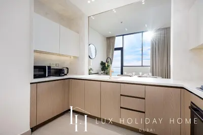 a kitchen with wooden cabinets and a counter top at LUX The Phantom Sky Pool Suite in Dubai