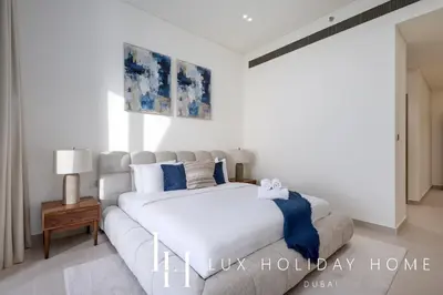 a bedroom with a white bed and a couch at LUX The Phantom Sky Pool Suite in Dubai