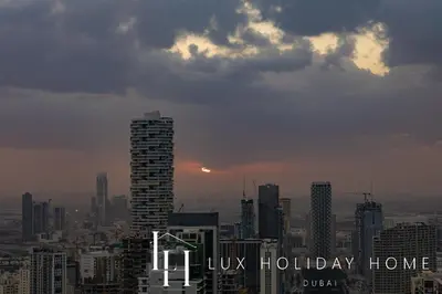 a city skyline with the sun setting in the sky at LUX The Phantom Sky Pool Suite in Dubai