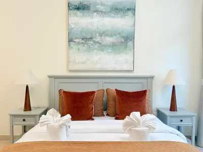 a bedroom with a bed with two lamps and a painting at Luxury Apartments in Burj Vista Dubai With Burj Khalifa View Near Dubai Mall in Dubai