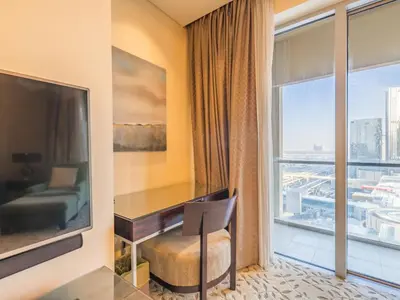 a hotel room with a desk and a large window at Direct Dubai Mall Access-Emaar Residences-1BR Like Home in Dubai