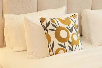 a pillow sitting on a bed with white pillows at Luxury Brand New 2 BR Apartment Burj & Canal View Business Bay Dubai in Dubai