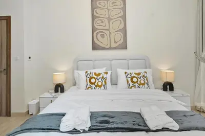 a bedroom with a large white bed with two lamps at Luxury Brand New 2 BR Apartment Burj & Canal View Business Bay Dubai in Dubai