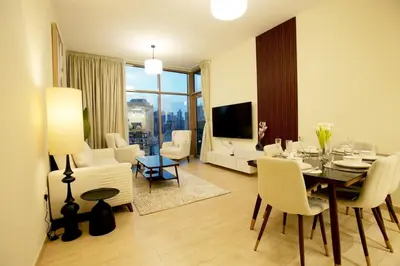 a living room with a table and chairs and a living room with a television at Luxury Brand New 2 BR Apartment Burj & Canal View Business Bay Dubai in Dubai