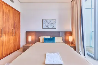 a bedroom with a large bed with two lamps at Burj Vista Luxury Apartments with Burj Khalifa View in Dubai