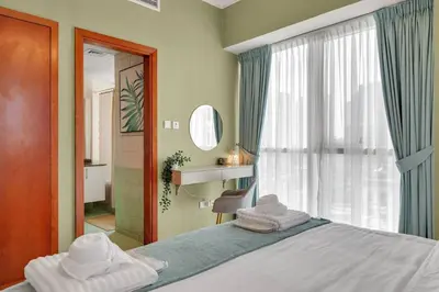 a bedroom with a bed and a window with towels on it at JLT Cozy and Modern 1BR Pool and Gym Walk to Metro in Dubai