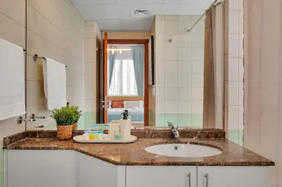 a bathroom with a sink and a mirror at JLT Cozy and Modern 1BR Pool and Gym Walk to Metro in Dubai