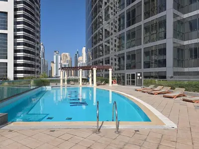 a large swimming pool in a city with buildings at JLT Cozy and Modern 1BR Pool and Gym Walk to Metro in Dubai