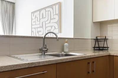 a kitchen sink with a bottle of soap on the counter at Burj Vista Modern Comfort - 1BR with Pool, Gym and Scenic views in Dubai