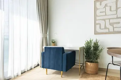 a blue chair in a room with a window at Burj Vista Modern Comfort - 1BR with Pool, Gym and Scenic views in Dubai