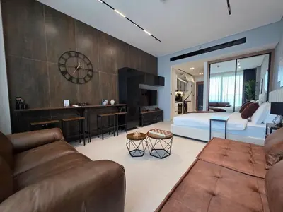 a living room with a couch and a bedroom at Trillionaire Bayhouse Chic Studio - Jacuzzi with views, Pool and Gym in Dubai