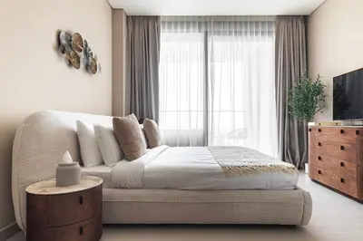 a bedroom with a bed and a large window at Trillionaire Bayhouse One- Private Jacuzzi, Sauna, pool and gym in Dubai
