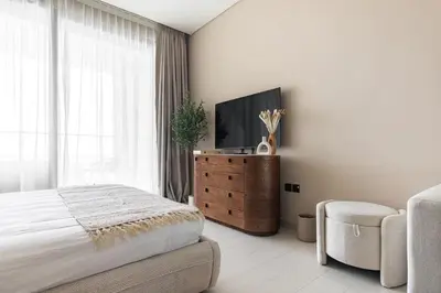 a bedroom with a bed and a tv and a chair at Trillionaire Bayhouse One- Private Jacuzzi, Sauna, pool and gym in Dubai