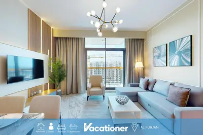 a living room with a blue couch and a tv at Vacationer l Elegant 1 Bed l Next to Metro l Near Mall in Dubai