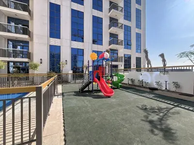 a playground with a slide in front of a building at Vacationer l Elegant 1 Bed l Next to Metro l Near Mall in Dubai