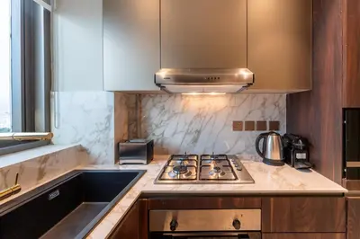 a kitchen with a stove top oven next to a sink at Vacationer l Elegant 1 Bed l Next to Metro l Near Mall in Dubai