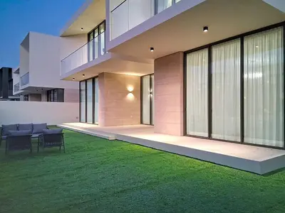 a house with a green lawn in front of it at Vacationer l Breathtaking 5 Bed Villa l Luxurious & Spacious in Dubai
