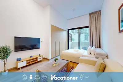 a living room with a couch and a flat screen tv at Vacationer l Peaceful Studio l Circle Mall l Greenery Community in Dubai