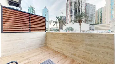a retaining wall in a city with tall buildings at Vacationer l Peaceful Studio l Circle Mall l Greenery Community in Dubai
