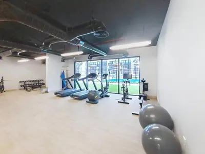a gym with cardio equipment and a large window at Vacationer l Peaceful Studio l Circle Mall l Greenery Community in Dubai