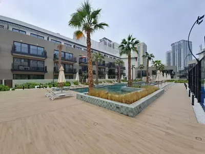 a courtyard with palm trees and a swimming pool at Vacationer l Peaceful Studio l Circle Mall l Greenery Community in Dubai