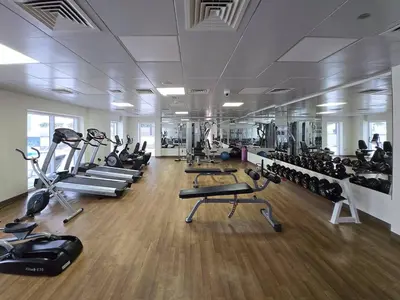 a gym with several treadmills and machines in a room at Business Bay 1 BR on Canal 7 min to Dubai Mall in Dubai