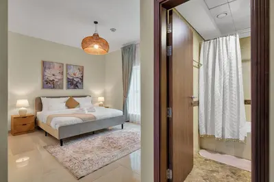 a bedroom with a bed and a hallway with a window at Business Bay 1 BR on Canal 7 min to Dubai Mall in Dubai