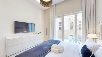 a bedroom with a large bed with a flat screen tv at Vacationer l Modern Aesthetic 1 Bed l JVC l near Circle Mall in Dubai