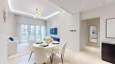 a white dining room with a white table and chairs at Vacationer l Modern Aesthetic 1 Bed l JVC l near Circle Mall in Dubai