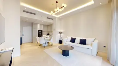 a living room with a white couch and a table at Vacationer l Modern Aesthetic 1 Bed l JVC l near Circle Mall in Dubai