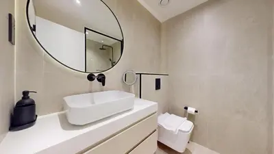 a bathroom with a white sink and a mirror at Vacationer l Modern Aesthetic 1 Bed l JVC l near Circle Mall in Dubai