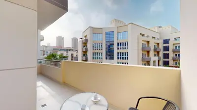 a balcony with a table and chairs and buildings at Vacationer l Modern Aesthetic 1 Bed l JVC l near Circle Mall in Dubai