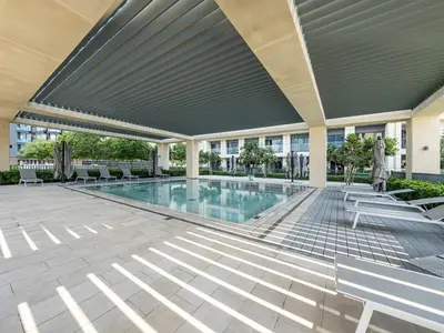 a swimming pool in a building with chairs and a building at Luxury 2 bed, 5 mins walk to Dubai Mall and Burj Khalifa in Dubai